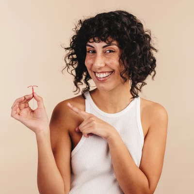 A person holds up a copper IUD and points to it as an example of one long term birth control option.