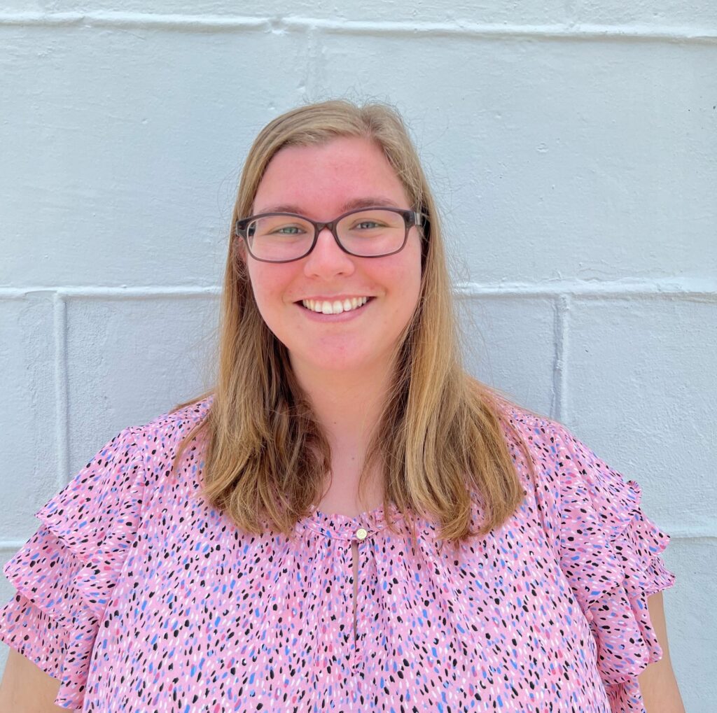 Metro Inclusive Health mental health professional Lauren Ballard with long blonde hair and glasses.