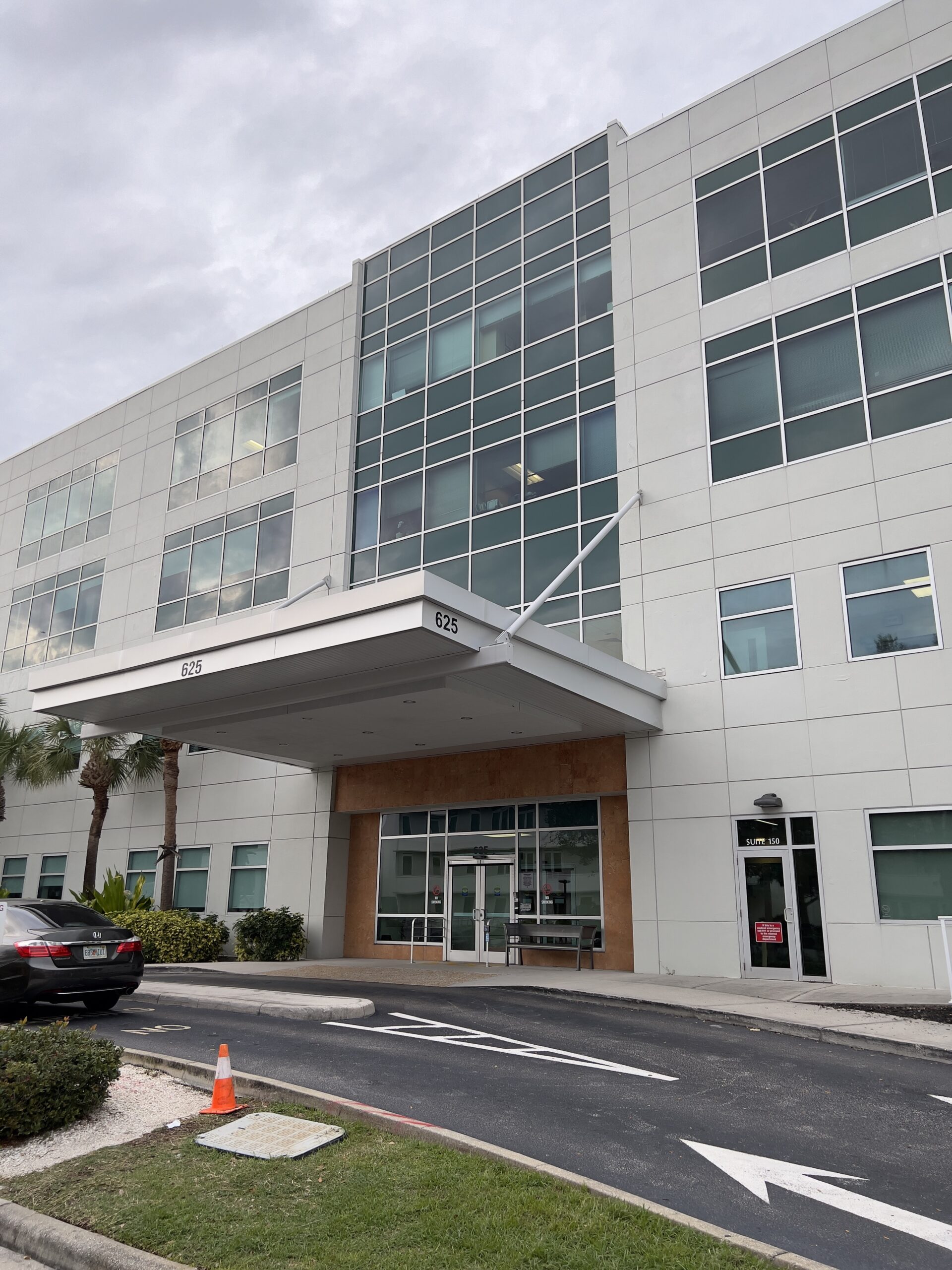 Front of our downtown St. Pete location, white awning covering brown walls with sliding glass doors